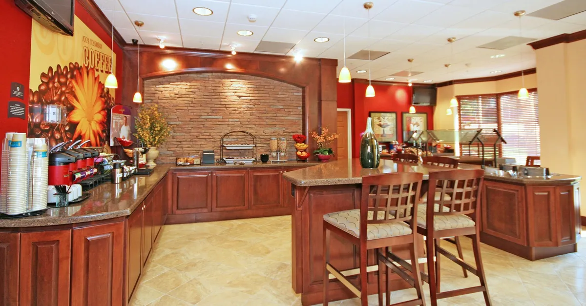 This image presents a cozy coffee station set against a stone accent wall, accompanied by a comfortable seating area and decorative touches. The area exudes a welcoming, home-like feel, ideal for casual dining or preparing a quick breakfast—activities that reflect a kitchen’s versatility for extended stays.